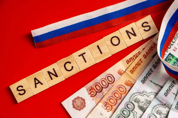 Billetes de rublo rusos emitidos por el Banco de Rusia sobre fondo rojo con cinta de bandera rusa. Rublo ruso bajo sanciones. Imagen De Stock