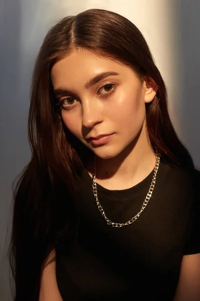 Retrato de joven dama caucásica con pelo largo, cadena de metal brillante en top negro —  Fotos de Stock