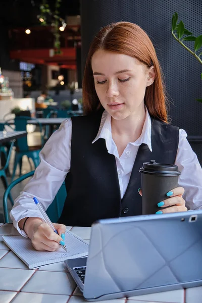 Καυκάσιος μαθητής κάθεται στο τραπέζι του καφέ, μελετώντας με το laptop, κάνοντας την εργασία — Φωτογραφία Αρχείου