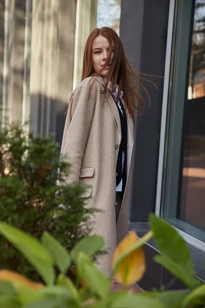 코트를 입고 긴 머리를 한 젊은 유카 시아붉은 머리 소녀의 야외 사진 — 스톡 사진