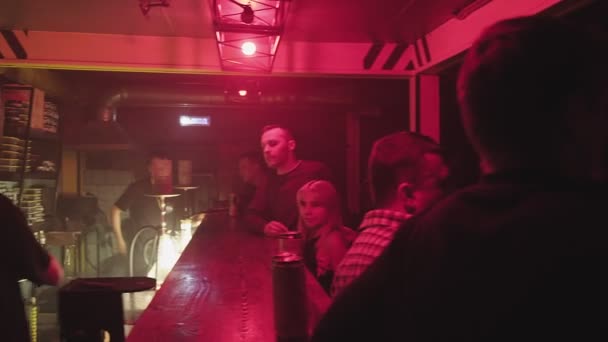 RUSIA, VLADIMIR, 02 OCT 2021: el cliente paga al barman por las bebidas en el bar de la discoteca — Vídeo de stock