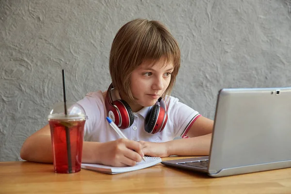 テーブルに座ってラトップで勉強してる白人の女の子。オンライン教育 — ストック写真