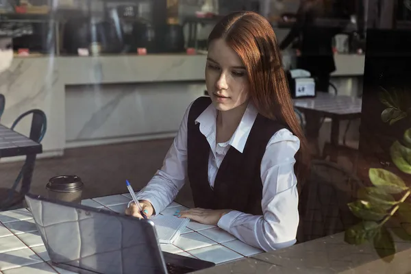 Καυκάσιος μαθητής κάθεται στο τραπέζι του καφέ, μελετώντας με το laptop, κάνοντας την εργασία — Φωτογραφία Αρχείου