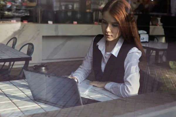 Kaukaski student siedzi przy stole kawiarni, uczy się z laptopem, odrabia lekcje — Zdjęcie stockowe