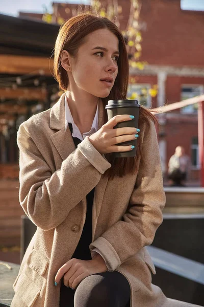 Joven caucásico pelirroja cabeza bonita chica en abrigo con el pelo largo y taza de café Fotos de stock