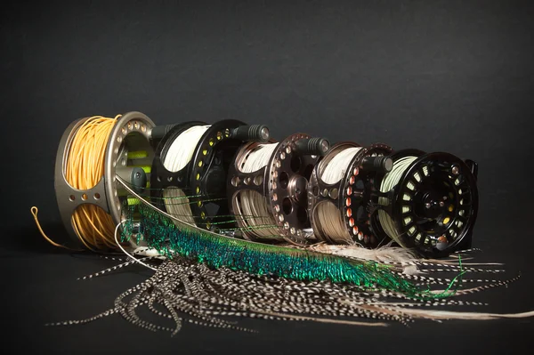 Fly fishing reel and feathers — Stock Photo, Image