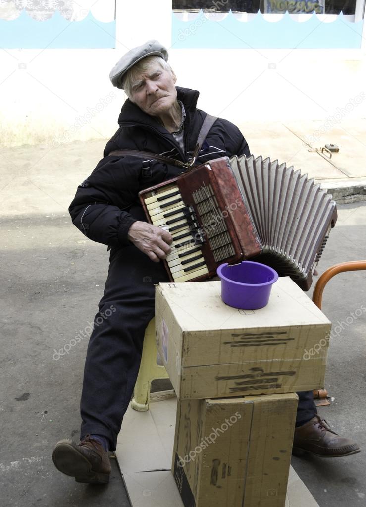 The old man plays the accordion.