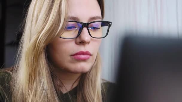 Νεαρή όμορφη κοπέλα με γυαλιά εργάζεται σε ένα φορητό υπολογιστή Βίντεο Κλιπ