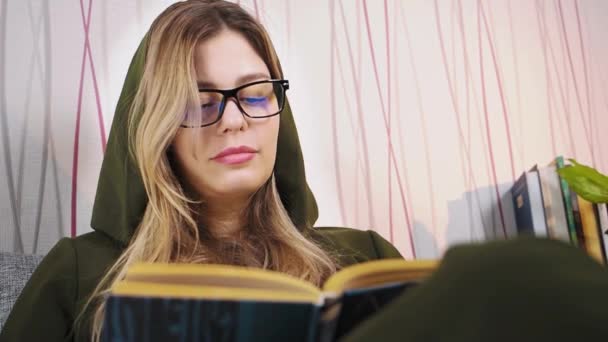 Junge schöne Frau mit Brille liest Buch — Stockvideo