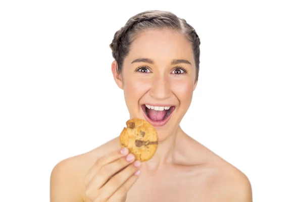 Greedy smiling model holding cookie — Stock Photo, Image