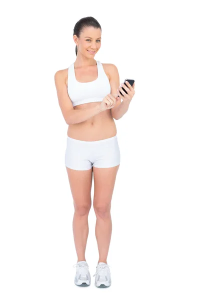 Mujer feliz en ropa deportiva mensajes de texto — Foto de Stock