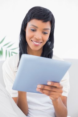 düşünceli siyah saçlı kadın Beyaz giysili bir tablet PC'yi kullanma