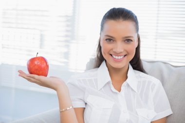 Kameraya bakarak Kırmızı elma tutan gülümseyen kadın