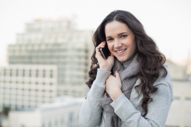 telefon sahip kış giyim gülümseyen güzel esmer