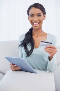 gülümseyen çekici kadın online satın almak için onun tablet PC'yi kullanma