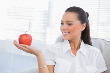 Holding ve Kırmızı elma seyir gülümseyen kadın