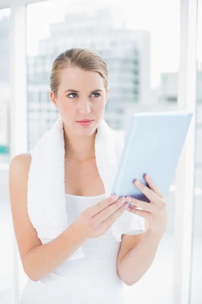 Thoughtful sporty woman holding tablet pc — Stock Photo, Image