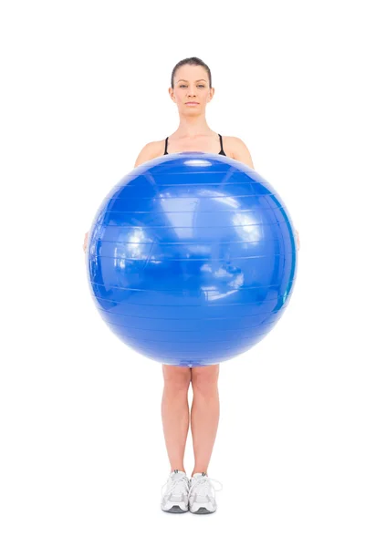 Relajada mujer en forma sosteniendo la pelota de ejercicio delante de ella —  Fotos de Stock