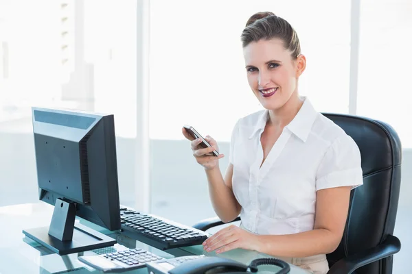 Glimlachende zakenvrouw met behulp van mobiele telefoon — Stockfoto