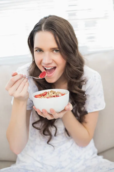 Bella donna in pigiama mangiare cereali fruttati — Foto Stock