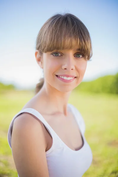 Lächelnde junge Frau posiert draußen — Stockfoto