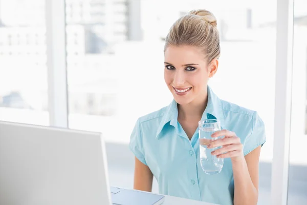Smiling well dressed businesswoman holding water — Stock Photo, Image