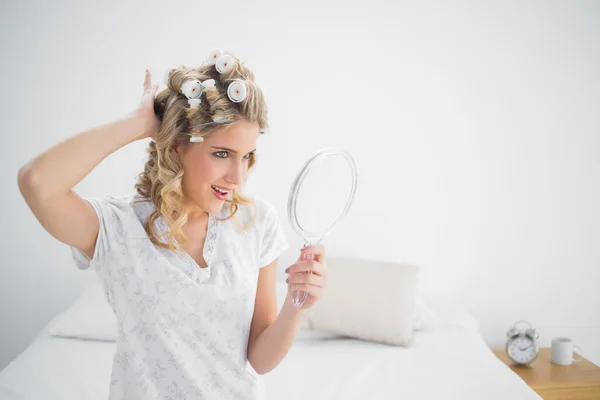 Cheerful gorgeous blonde wearing hair curlers posing — Stock Photo, Image