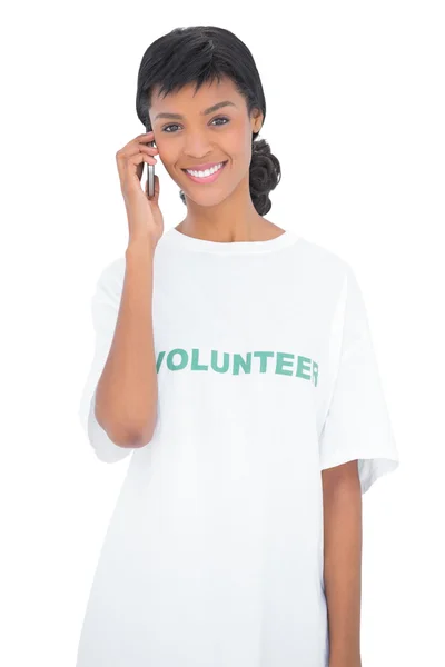 Attractive black haired volunteer calling someone with her mobile phone — Stock Photo, Image