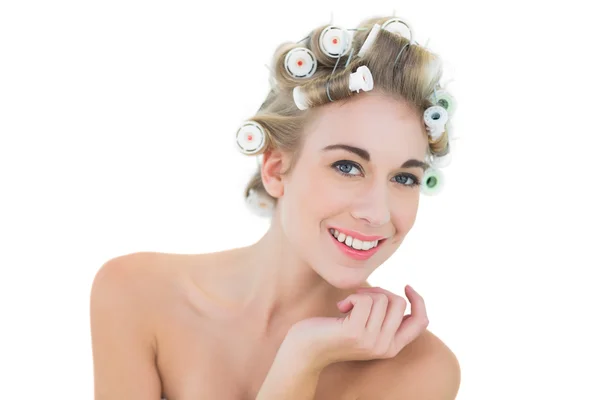 Pleased blonde model in hair curlers looking at camera — Stock Photo, Image