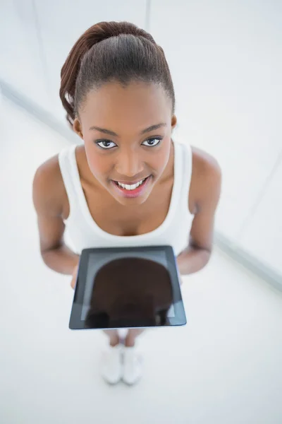 Vista de ángulo alto de la sonriente mujer deportiva sosteniendo la tableta —  Fotos de Stock