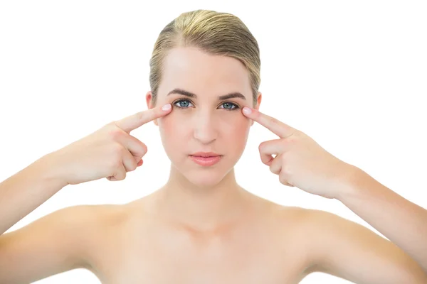 Pretty blonde pointing at her crows feet — Stock Photo, Image