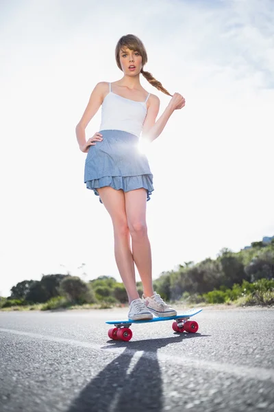 Astonished young woman balancing on her skateboard — Stock Photo, Image