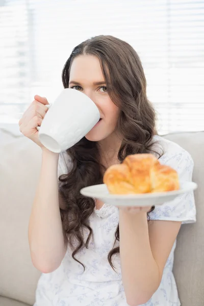 Fröhliche junge Frau im Pyjama beim Frühstück — Stockfoto