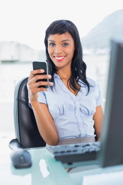 Charmante zakenvrouw houden van een mobiele telefoon — Stockfoto