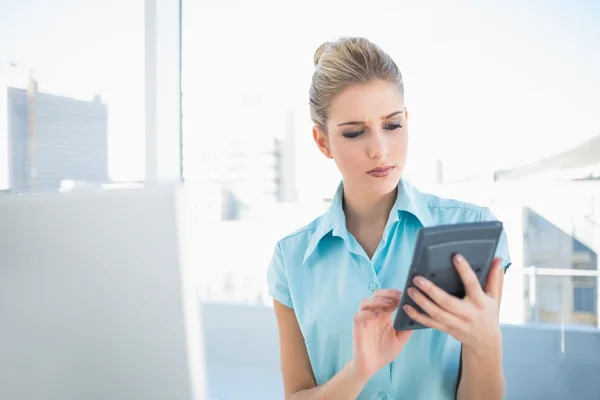 Fruncir el ceño mujer elegante usando calculadora — Foto de Stock