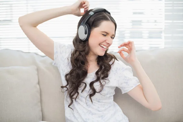 Lächelnde junge Frau tanzt, während sie Musik hört — Stockfoto