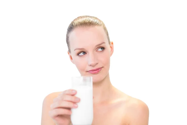 Pensive pretty blonde model holding a glass of milk — Stock Photo, Image