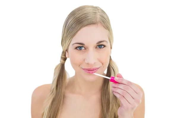 Amused young blonde woman applying gloss — Stock Photo, Image