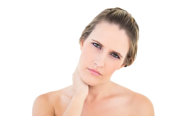 Upset woman looking at camera with a sore neck — Stock Photo, Image