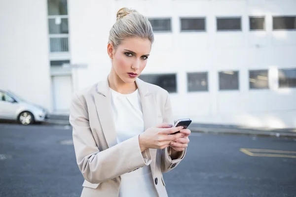 Ernsthafte stilvolle Geschäftsfrau schickt einen Text — Stockfoto
