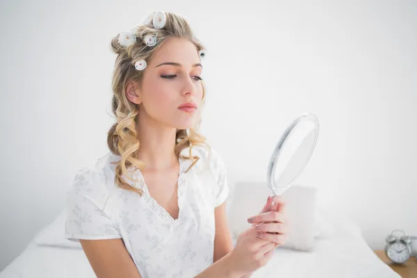 Ontspannen blonde kijken spiegelbeeld op gezellige bed — Stockfoto