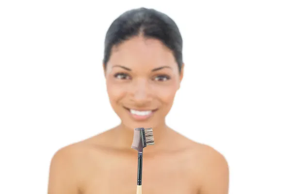 Fröhliche schwarzhaarige Modell hält Augenbrauenbürste — Stockfoto