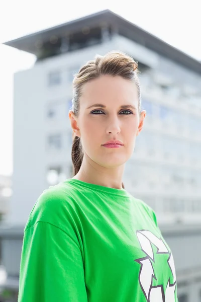 ニコリともしない女性のリサイクルのシンボルと緑のシャツを着ています。 — ストック写真