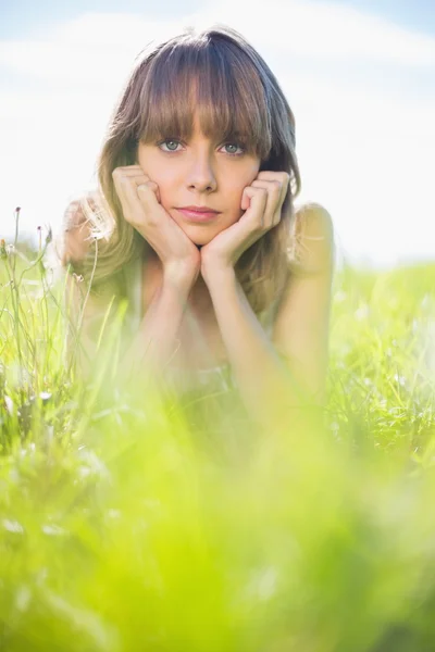 Hübsche junge Frau im Gras liegend — Stockfoto