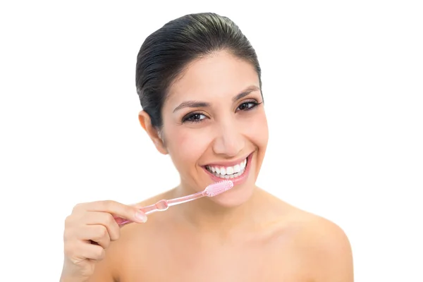 Brunette haar tanden poetsen en glimlachen op camera — Stockfoto