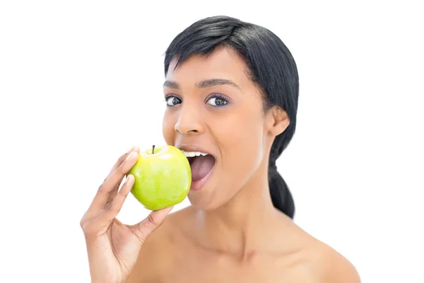 Encantada mulher de cabelos pretos comendo uma maçã — Fotografia de Stock