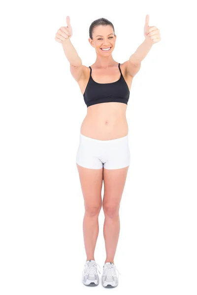 Cheerful woman in sportswear giving thumbs up to camera — Stock Photo, Image