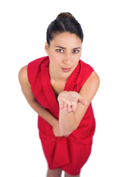 Geheimnisvolle Brünette im roten Kleid schickt einen Kuss in die Kamera — Stockfoto