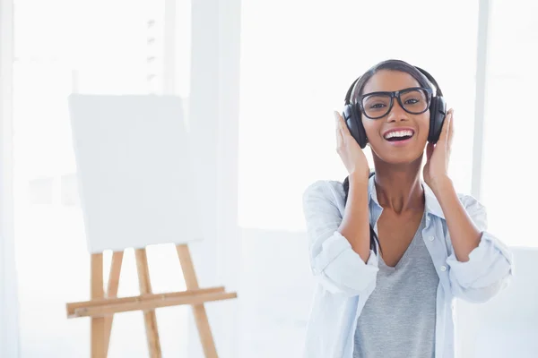 Smiling attractive artist listening to music — Stock Photo, Image