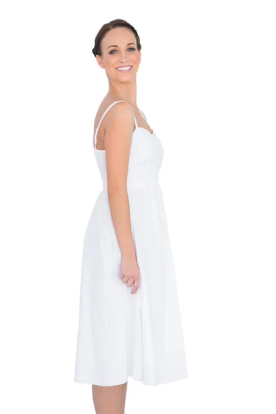 白いドレスのポージングで笑顔の美しい若いモデル — ストック写真